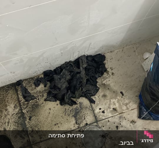 רצפה מלוכלכת עם סמרטוטים שחורים ליד שירותים